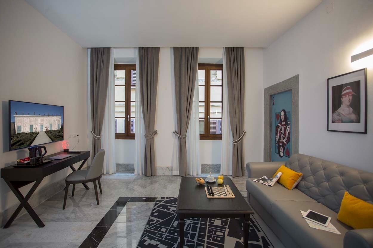 Modernes Zimmer im Casual Rinascimento Firenze mit TV, Schreibtisch und Sitzgelegenheiten. Zentral gelegen.