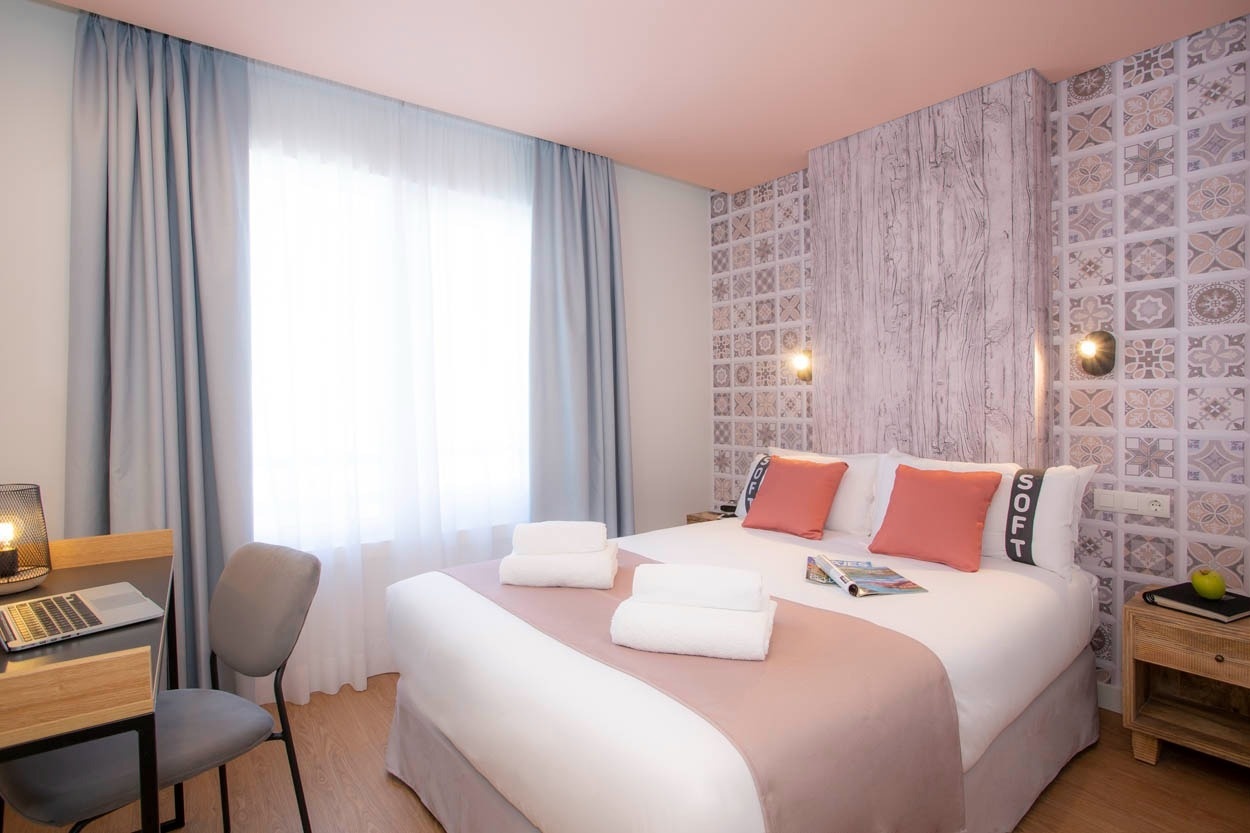 Camera moderna Casual Raízes Porto con letto confortevole e scrivania. Ideale per relax.