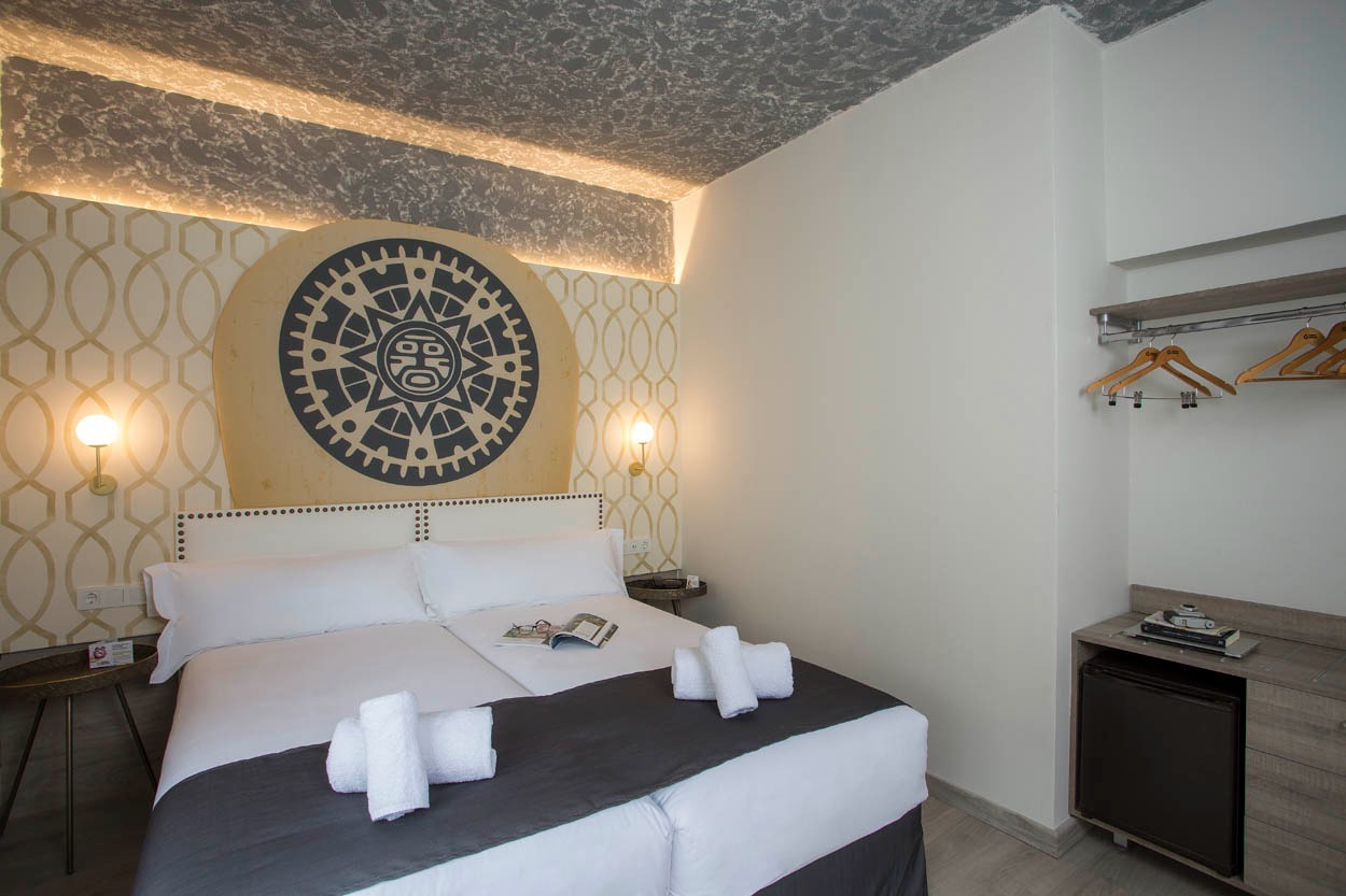 Gemütliches Zimmer im Casual Inca Porto: Doppelbett, Maya-Dekor und Minibar.
