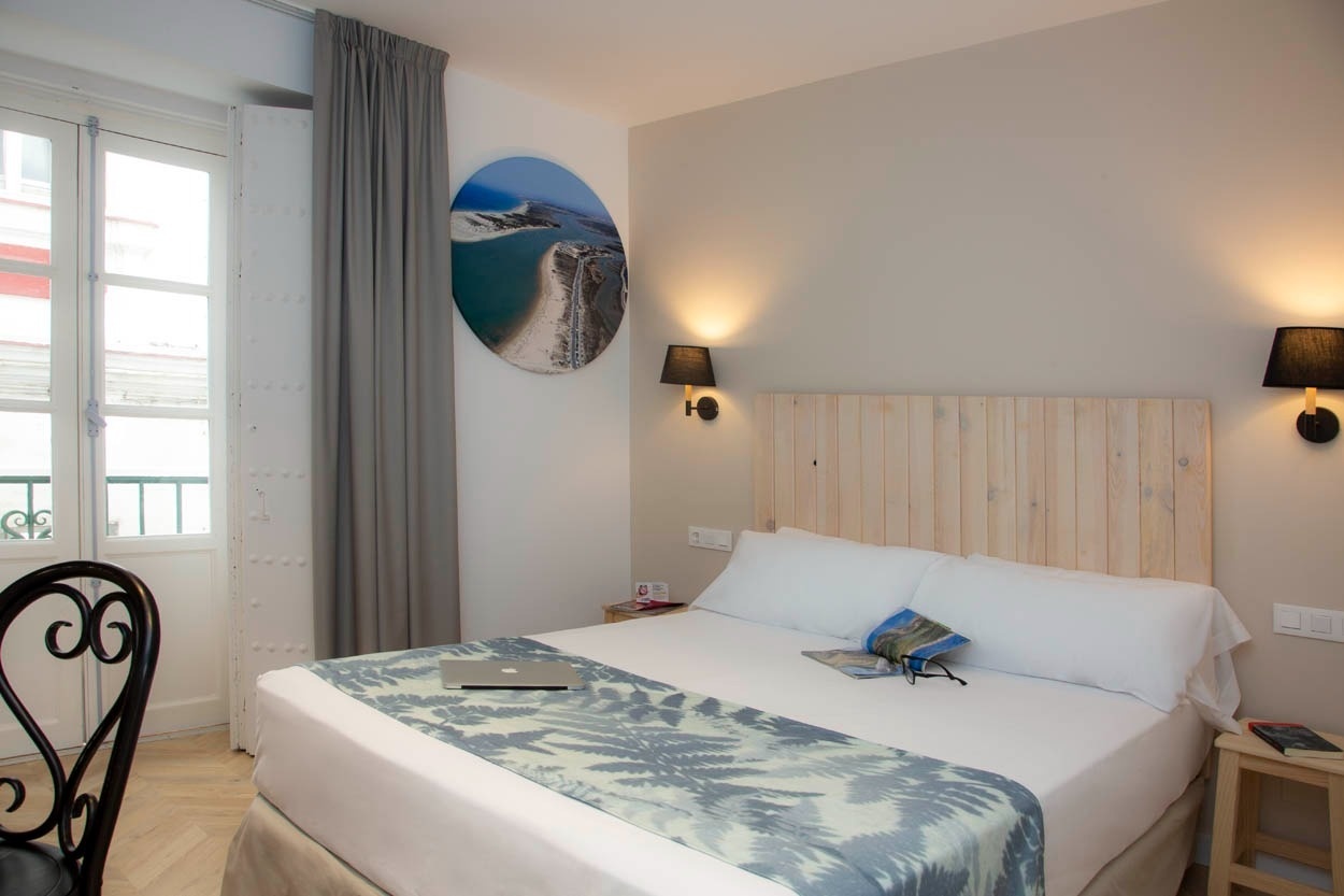 Gemütliches Hotelzimmer im historischen Zentrum von Cádiz mit Doppelbett und Fenster. Casual con Duende Cádiz - Hotel im historischen Zentrum von Cádiz | Casual Hoteles