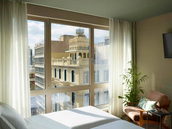 een hotelkamer met twee bedden en een groot raam