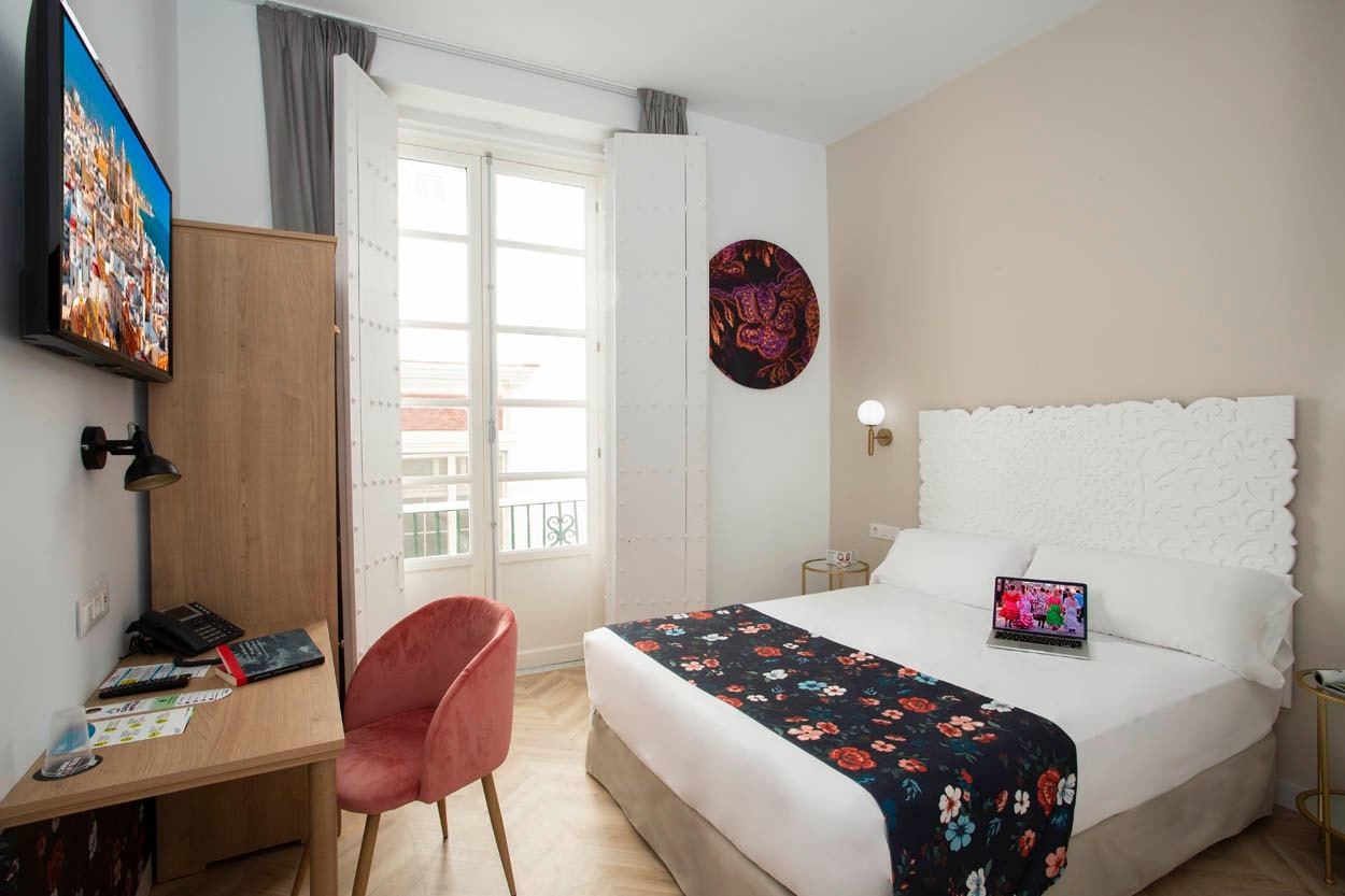 Komfortables Zimmer im Casual con Duende Cádiz mit Doppelbett, Schreibtisch und TV.