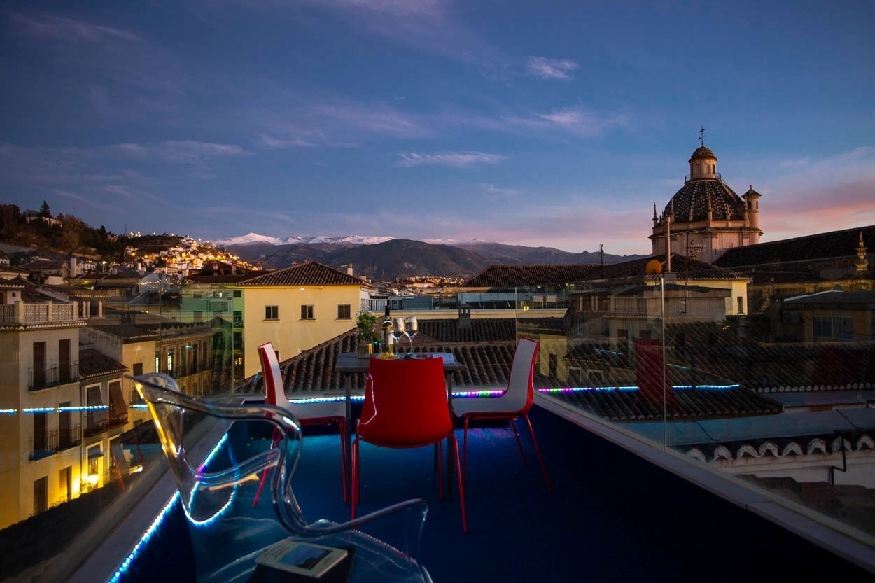 Terraza de Casual Ilbira Granada con vistas a Sierra Nevada al atardecer.