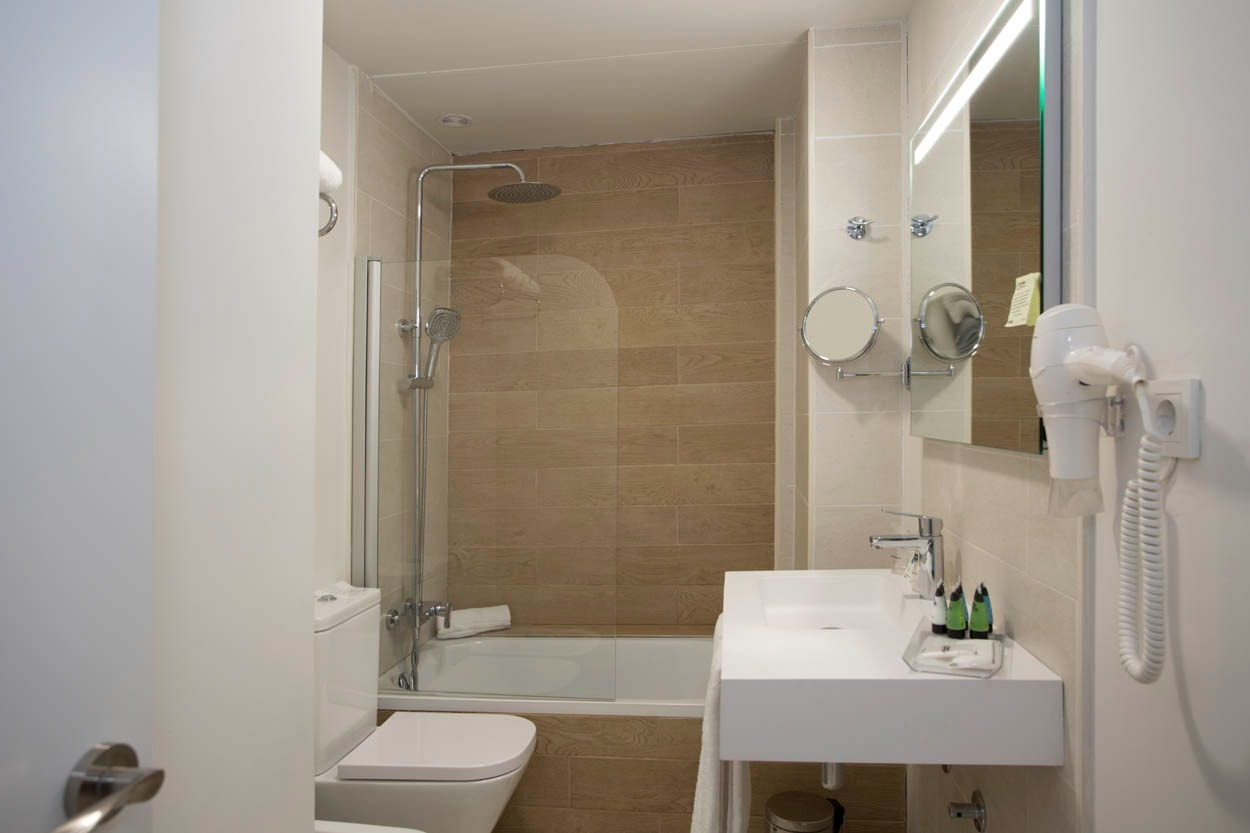 Modernes Badezimmer im Casual Inca Porto – Zentrales Hotel in Porto mit Dusche, Waschbecken und Haartrockner.
