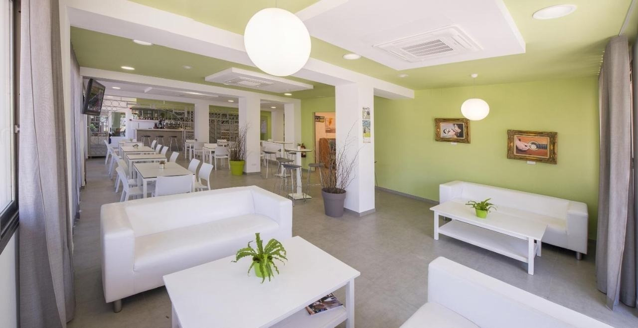 a living room with white furniture and green walls