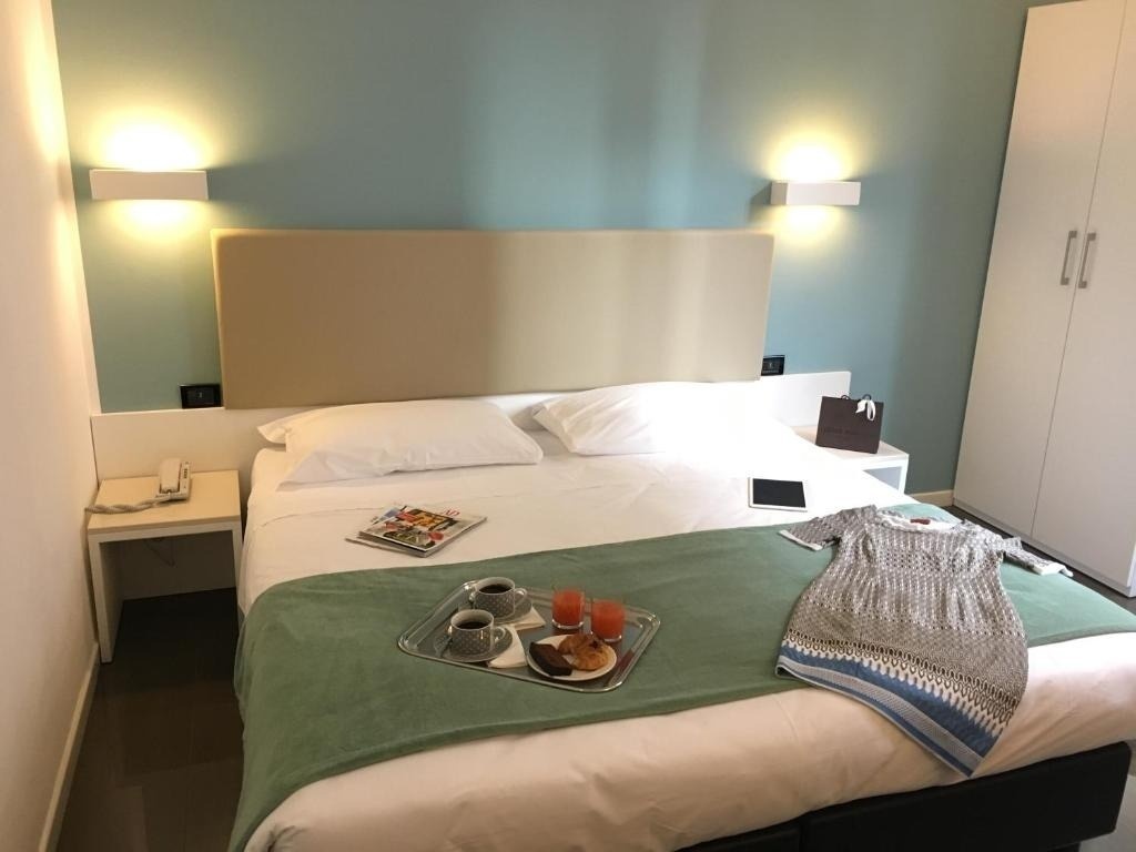 a hotel room with a tray of food on the bed