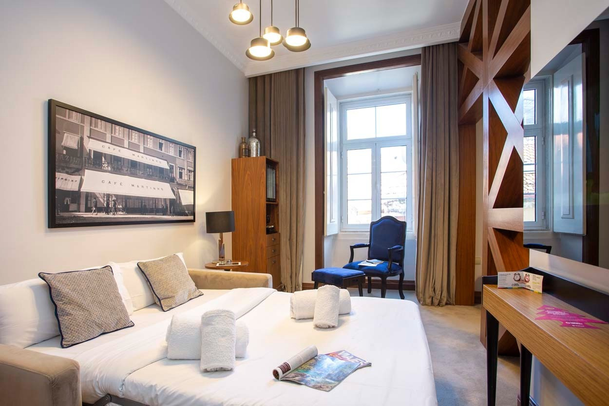 Modernes Hotelzimmer mit Blick auf die Straße Café Martinho – Casual Belle Époque Hotel in Lissabon.