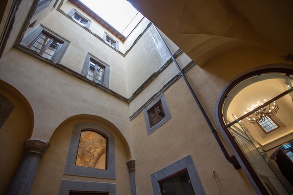 looking up at a building with arches and windows