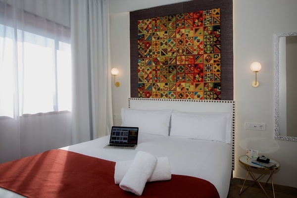 a laptop sits on a bed in a hotel room