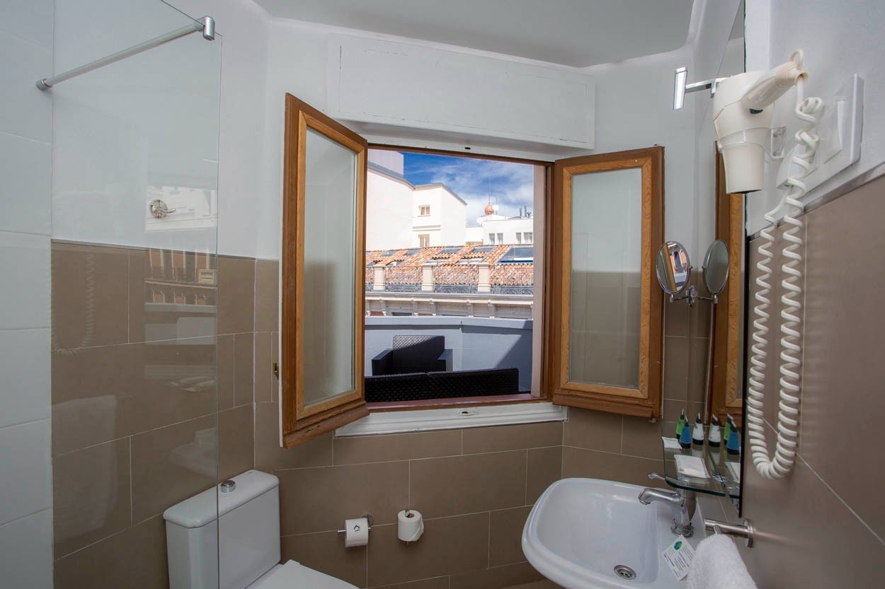 Badezimmer im Casual del Teatro Madrid - Boutique-Hotel nahe Gran Vía mit Dusche, Toilette und Waschbecken.