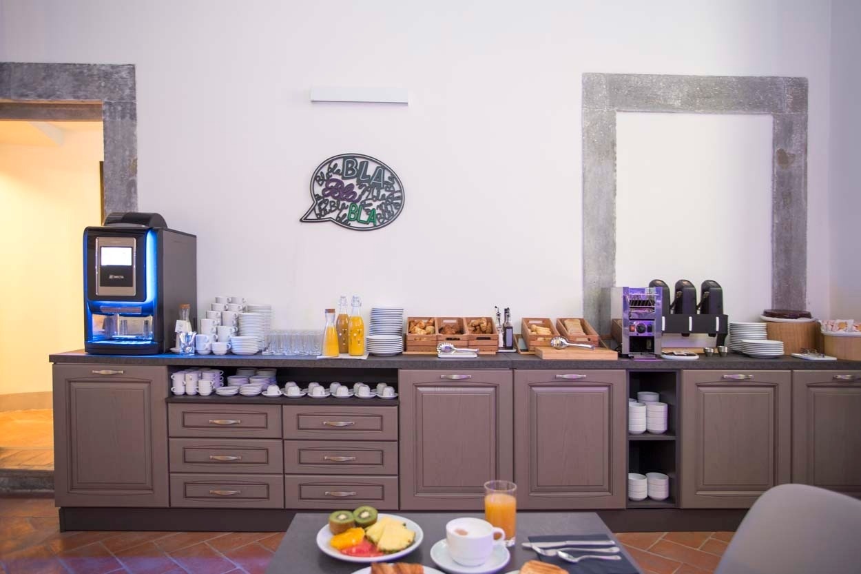 Frühstücksbuffet mit Kaffeeautomat und Säften im Casual Rinascimento Firenze - Zentrales Hotel mit Pool in Florenz.