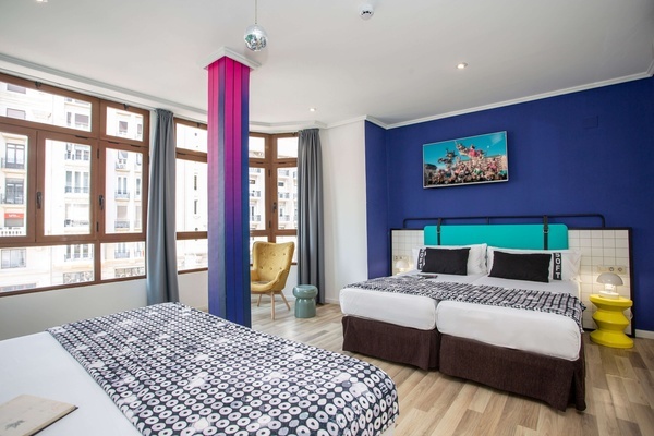 una habitación de hotel con dos camas y una silla