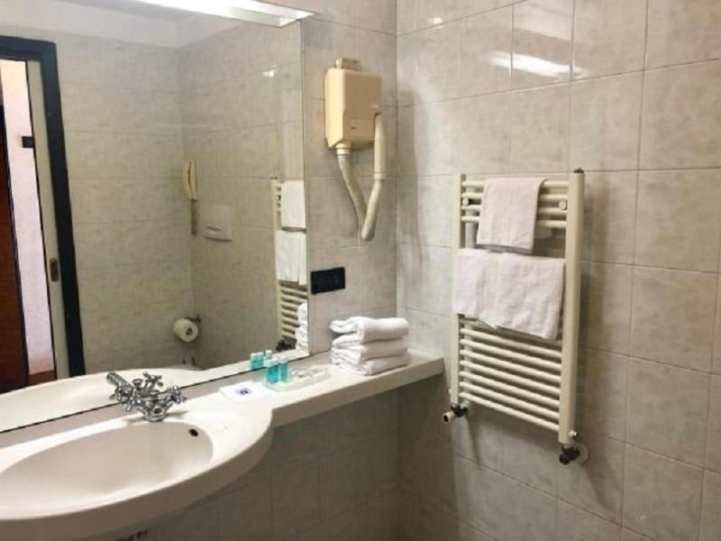 a bathroom with a sink , mirror and towel rack .