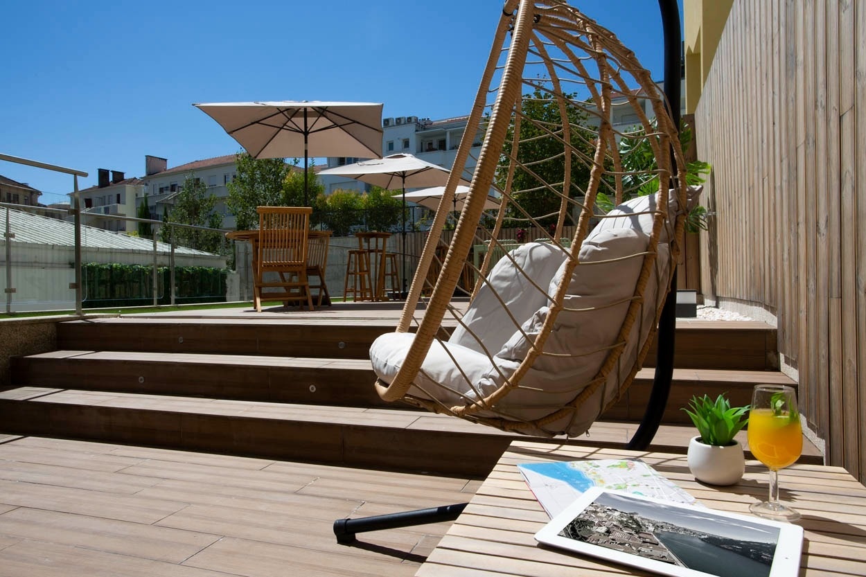 Relax in un'altalena da esterno accogliente con una bevanda rinfrescante. Casual Raízes Porto Hotel
