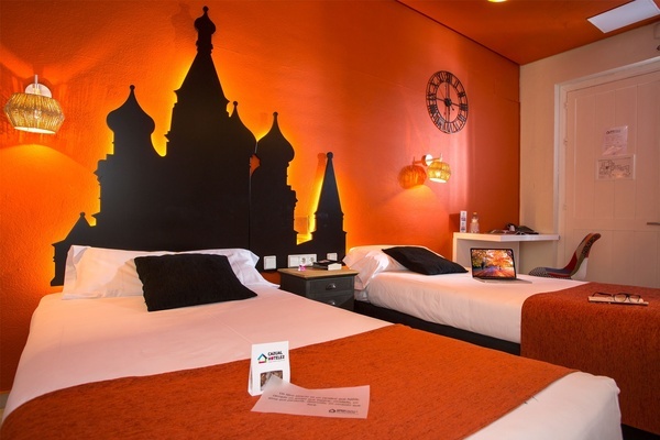 a hotel room with two beds and a clock on the wall