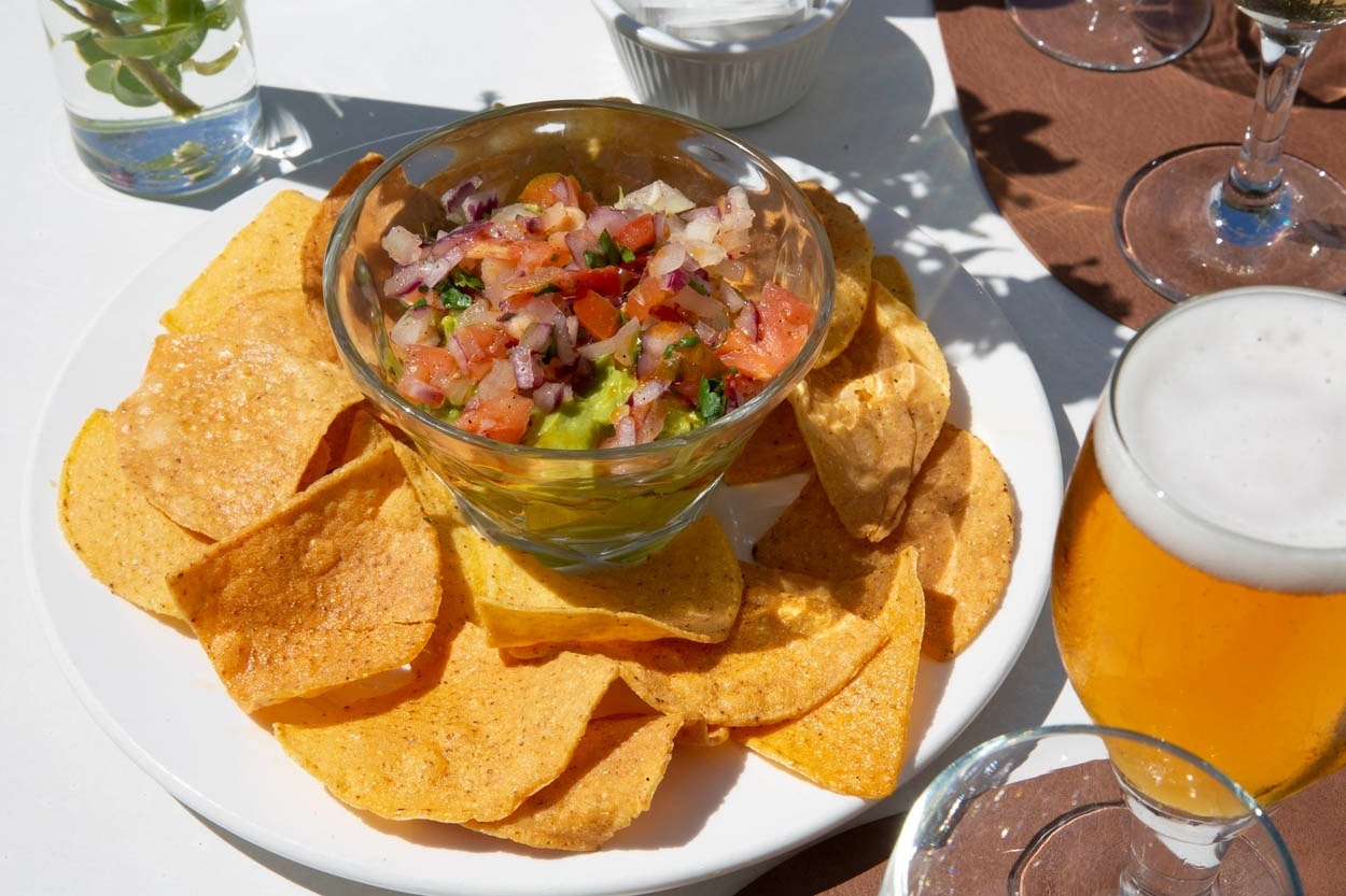 Guacamole avec chips et bière, idéal pour un repas décontracté à Casual Bahía Ibiza - Hôtel près de la plage à Ibiza.