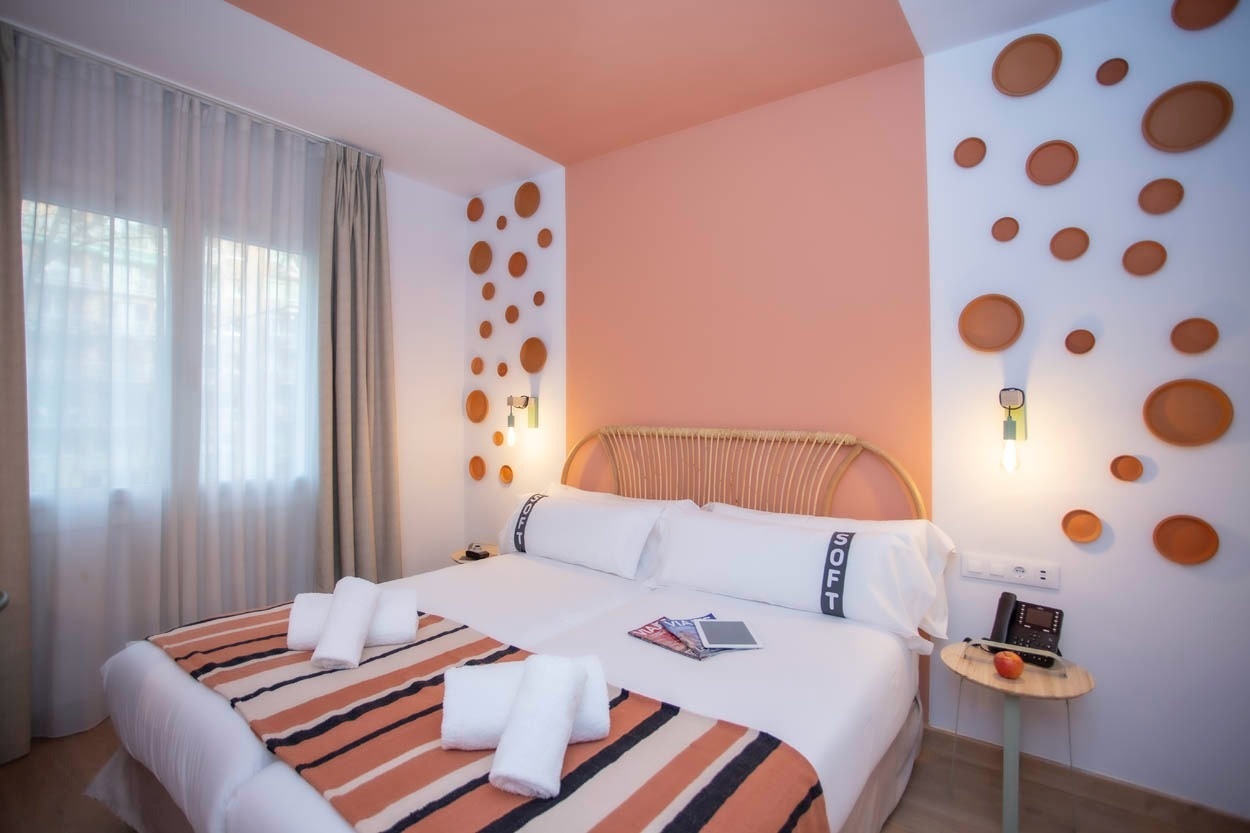 Hotelkamer met oranje accenten, comfortabel bed en een stijlvolle fauteuil in Casual Colours Barcelona - Hotel in de buurt van Sants in Barcelona | Casual Hoteles.