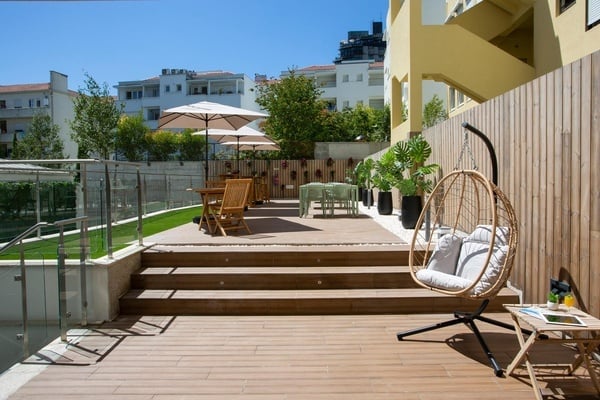a wooden deck with a hanging chair and a table