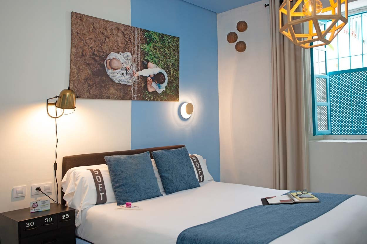 Komfortables Bett im Casual de las Letras Sevilla: Charmantes Hotel mit literarischem Thema in Sevilla.