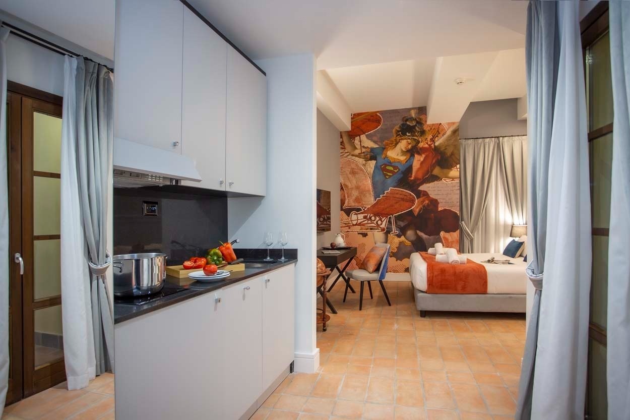 Modernes Apartment im Casual Rinascimento Firenze: Küche & Bett mit Superhelden-Wandbild.