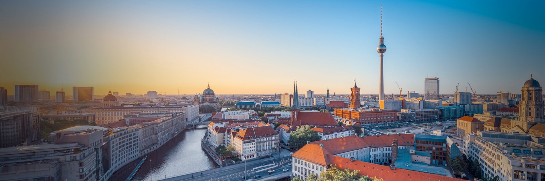 Een panoramisch uitzicht op de skyline van Berlijn met de Fernsehturm, de rivier de Spree en historische architectuur tijdens zonsopgang of zonsondergang.