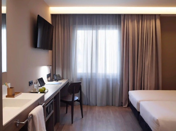 een hotelkamer met twee bedden en een bureau