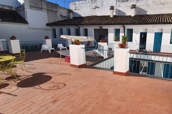 a balcony with a table and chairs and a blue door with the number 24 on it
