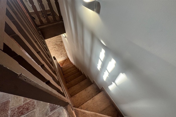 a wooden staircase with a white wall behind it