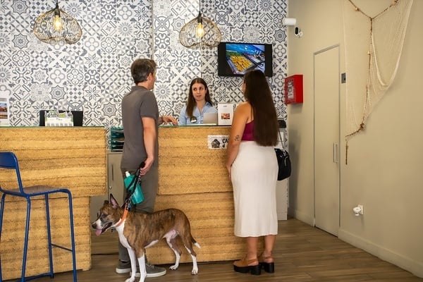 un hombre y una mujer con un perro en la recepción de un hotel
