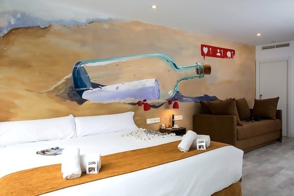 una habitación con una pintura de una botella en la pared