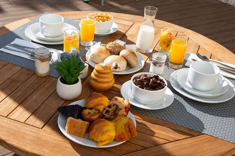 une table en bois avec des assiettes de nourriture et des jus d' orange