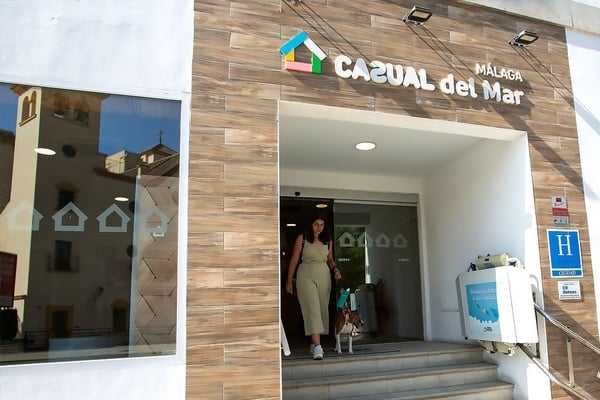 una mujer camina con su perro por la puerta del casual del mar