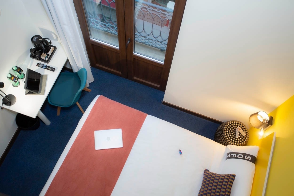 Habitación moderna en el centro: cama, escritorio y balcón. Casual Ilbira Granada - Hotel boutique.