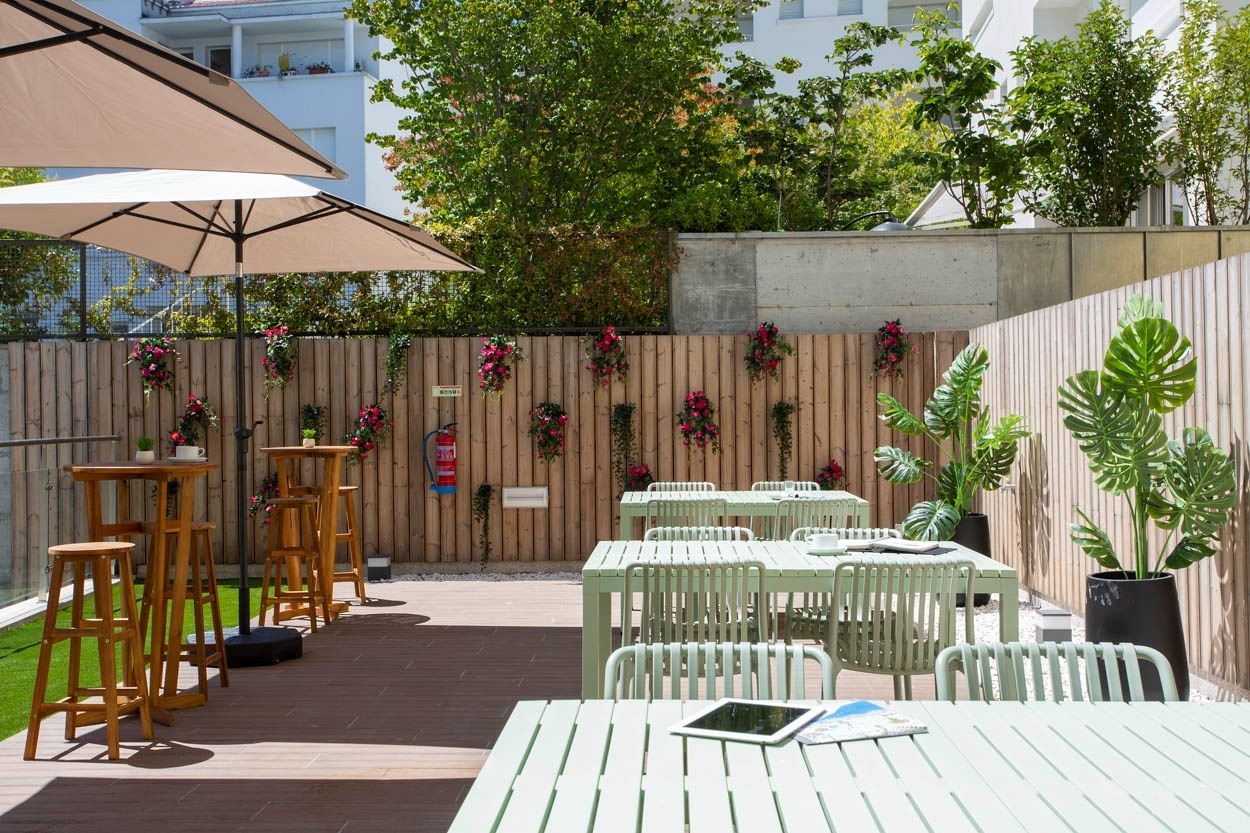 Terrazza casual con tavoli e sedie, perfetta per rilassarsi al Casual Raízes Porto - Boutique hotel vicino a Santa Catarina.
