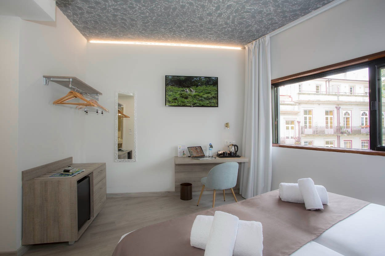 Modernes Hotelzimmer im Casual Inca Porto mit Schreibtisch, TV und Blick auf die Stadt. Perfekt für Ihren Aufenthalt in Porto.