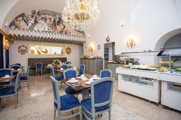 a dining room with blue chairs and a chandelier