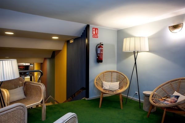 une salle avec des chaises et des lampes et un extincteur accroché au mur