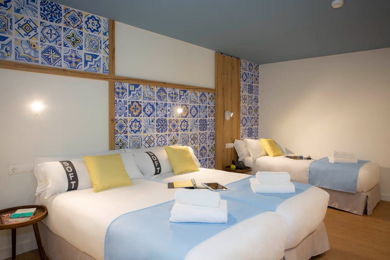 Camere del Casual Raízes Porto - Boutique hotel vicino a Santa Catarina con letti singoli e decorazioni in azulejo.