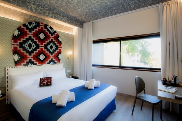 a hotel room with a large bed and a laptop on it