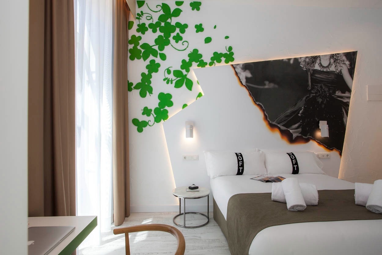 Habitación moderna con mural floral y foto artística en Casual Socarrat Valencia. ¡Reserva tu estancia!