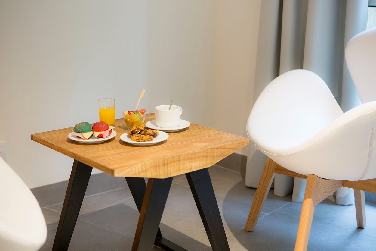 Ein Frühstückstablett mit Getränken und Snacks auf einem Holztisch im Casual de las Olas San Sebastián – Themenhotel.
