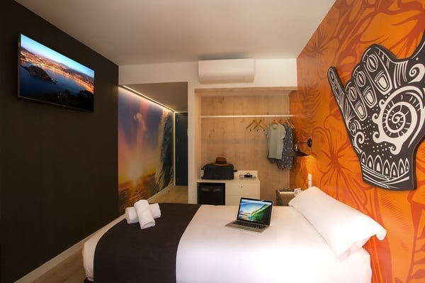 um quarto de hotel com uma cama e um laptop