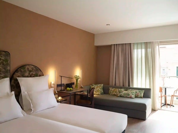 een hotelkamer met twee bedden en een bank