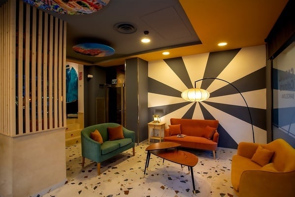 un salon avec des meubles colorés et un mur rayé