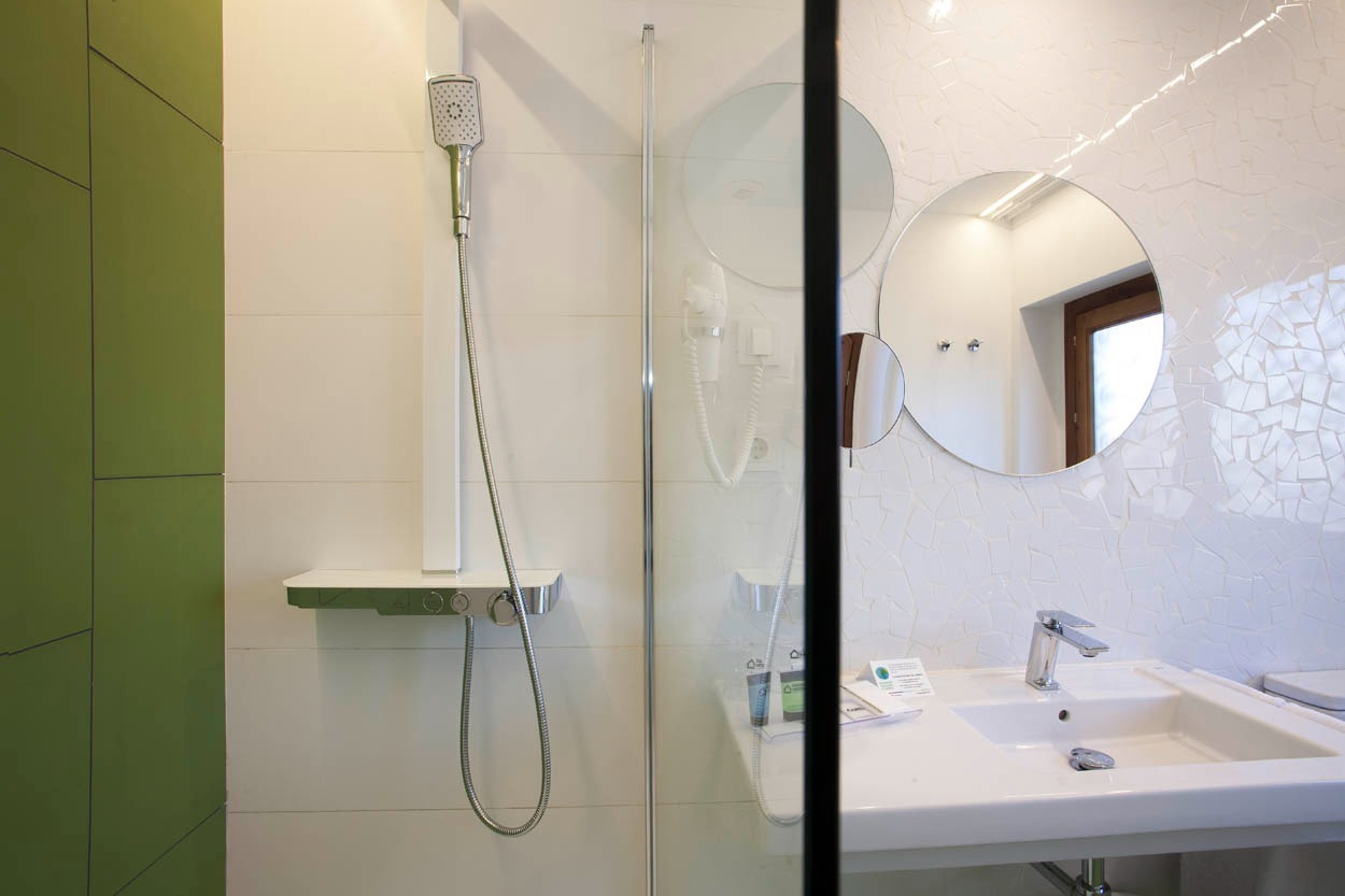Baño moderno en Casual Socarrat Valencia: ducha, lavabo y espejo.