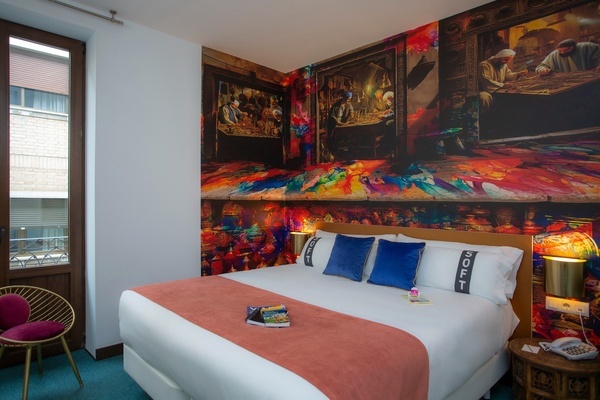 um quarto de hotel com uma cama e uma pintura na parede