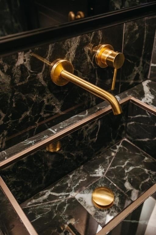 un lavabo en marbre noir avec un robinet en laiton .