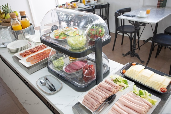 un comptoir rempli de nourriture y compris du bacon et des salades
