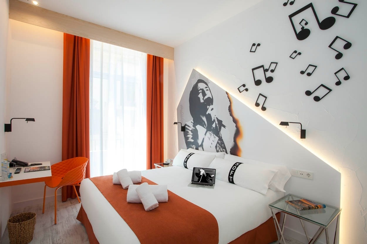 Habitación temática de música con mural de artista, notas musicales y colores vibrantes en Casual Socarrat Valencia.