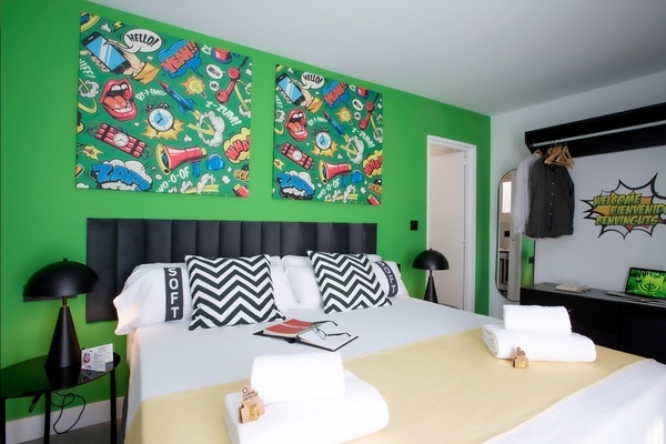 una habitación con una cama y dos cuadros en la pared